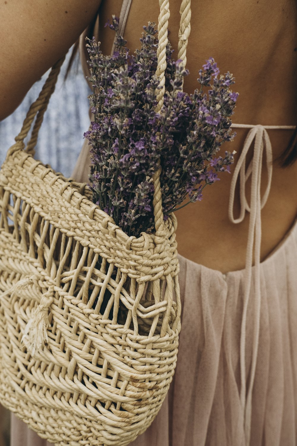woman in white tank top holding brown woven basket