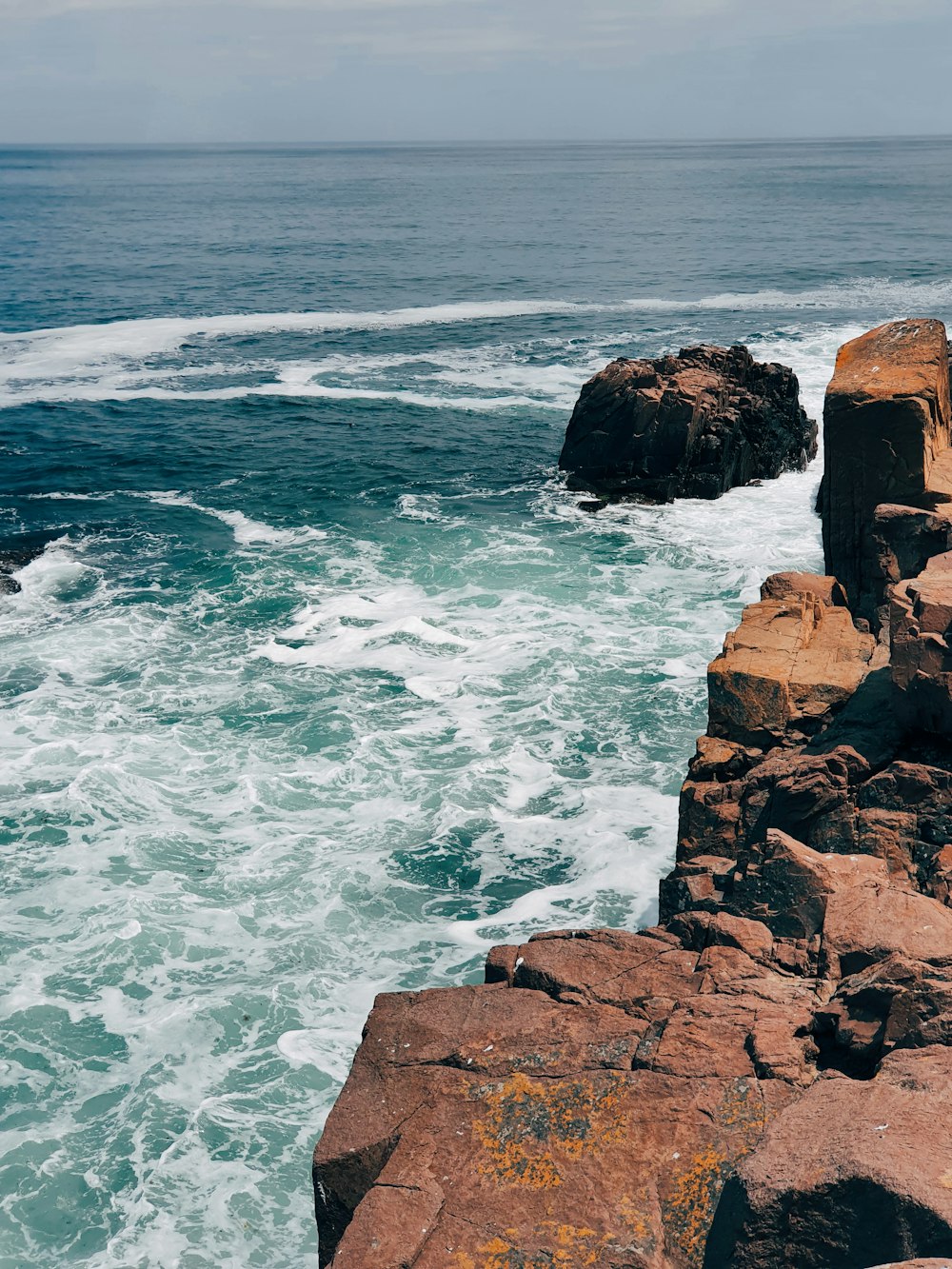 brown rock formation on sea during daytime