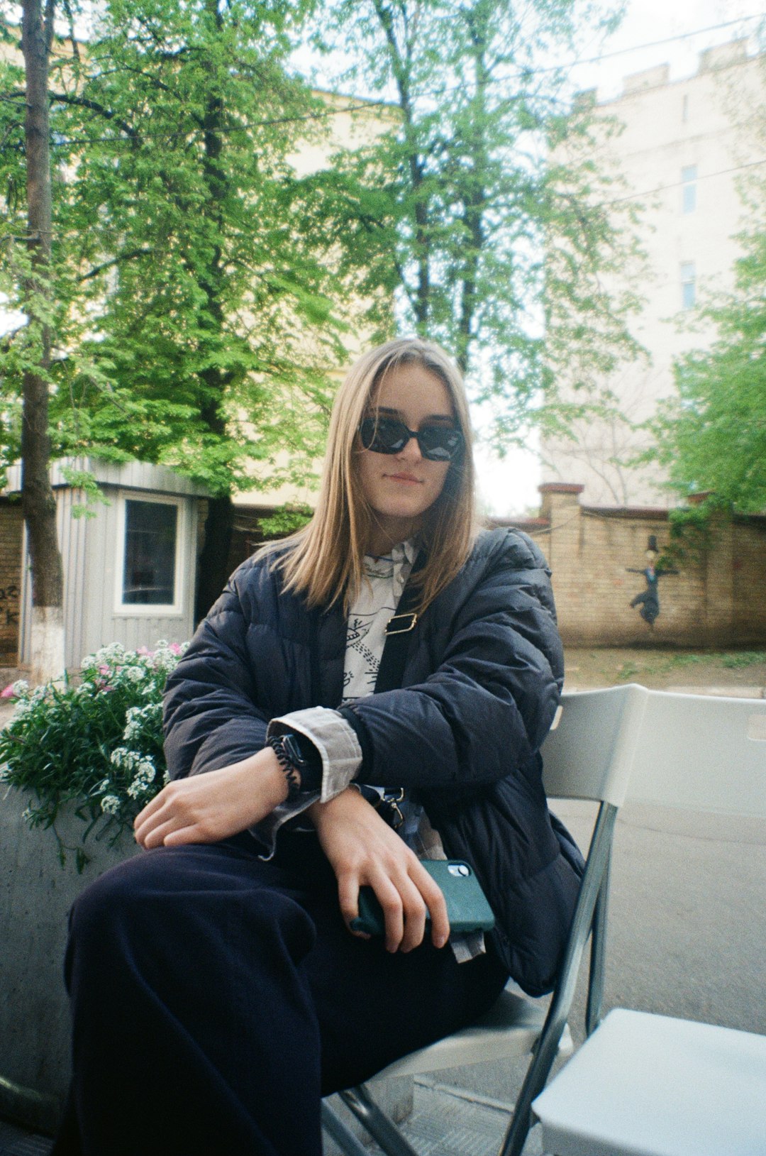 woman in black jacket sitting on white chair