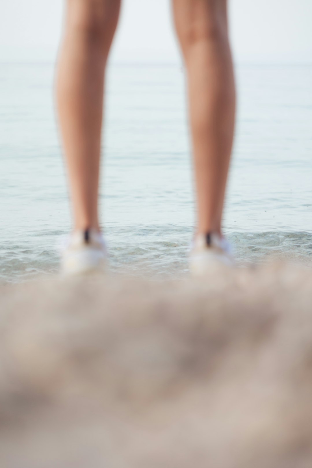 woman in white panty standing on beach during daytime