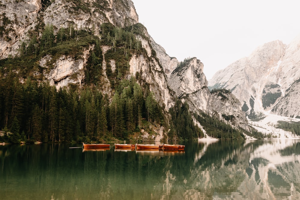 brown boat on lake near mountain during daytime