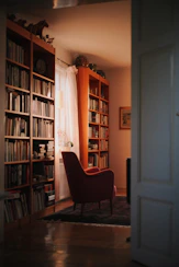 Cozy reading nook with a lamp casting warm light over a pile of books.