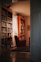 A cozy reading nook with a stack of colorful fiction books and a warm lamp.