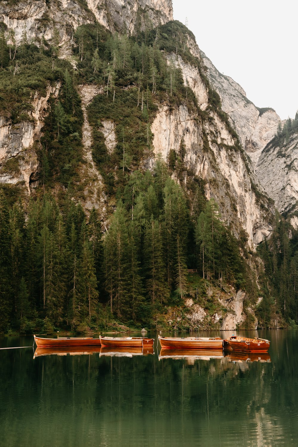 brown wooden boat on lake near mountain during daytime