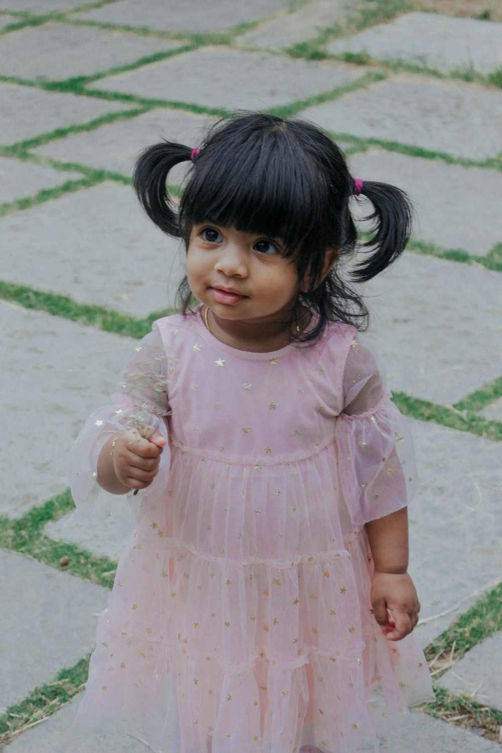 girl in pink dress standing on concrete floor