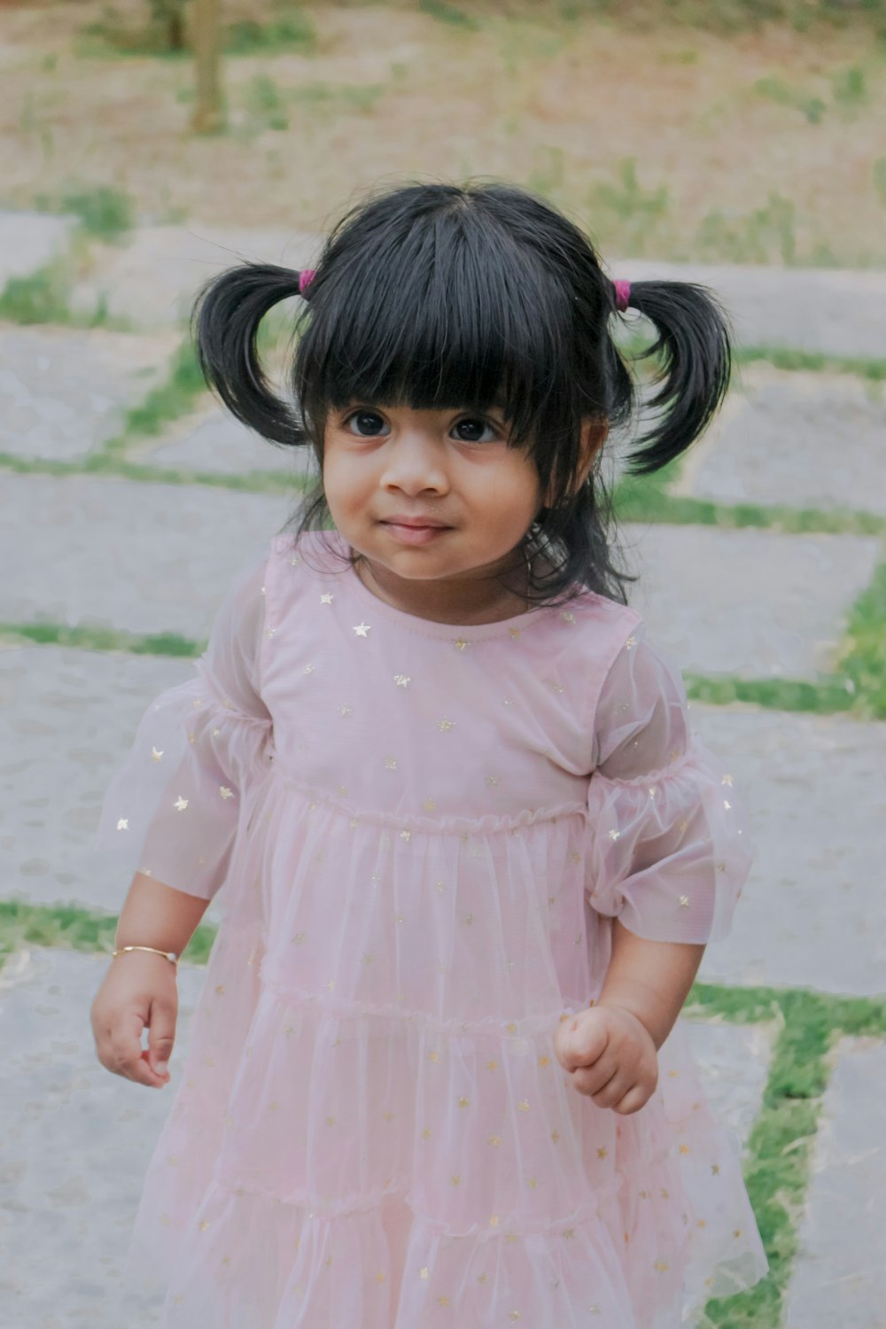 girl in pink dress standing on the ground