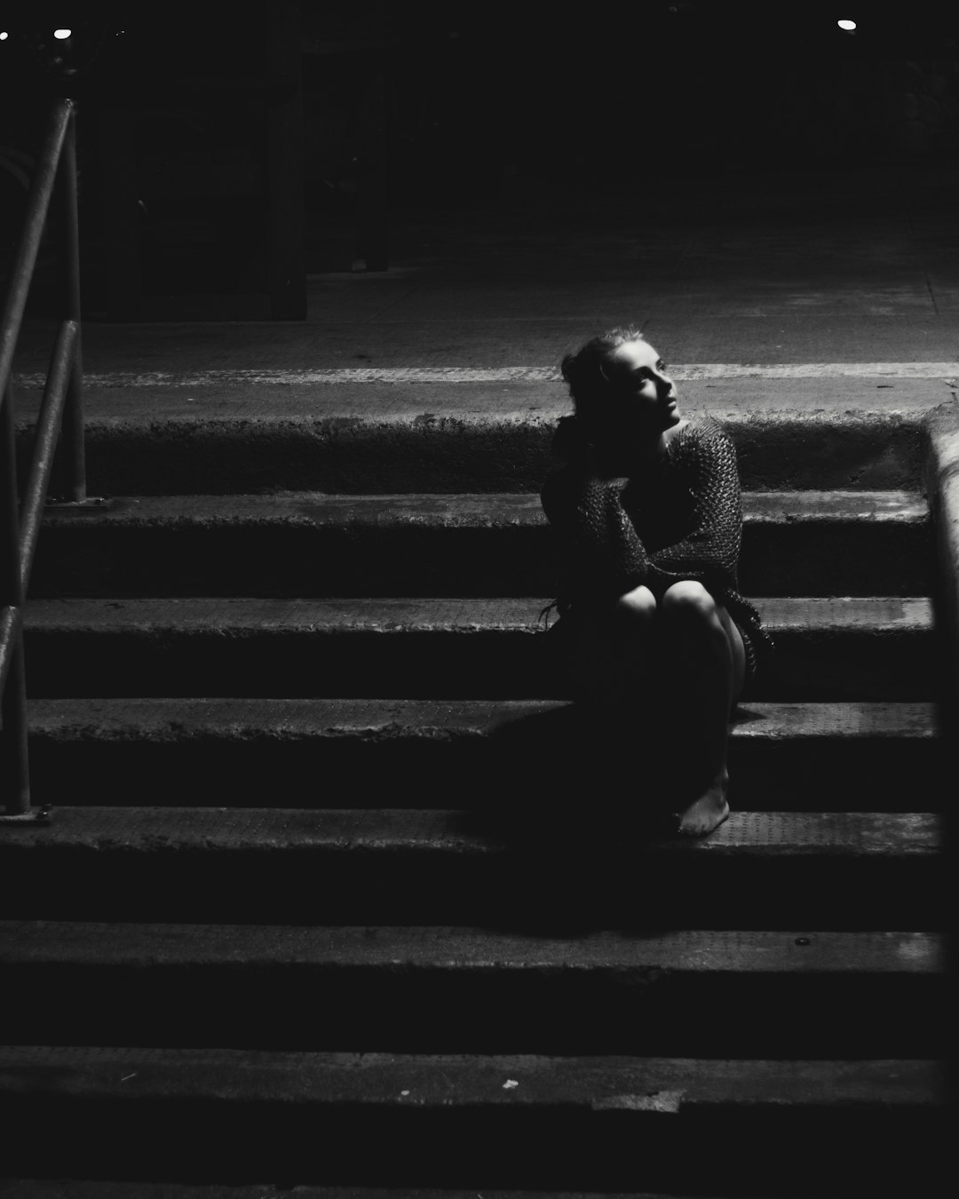 grayscale photo of woman sitting on stairs