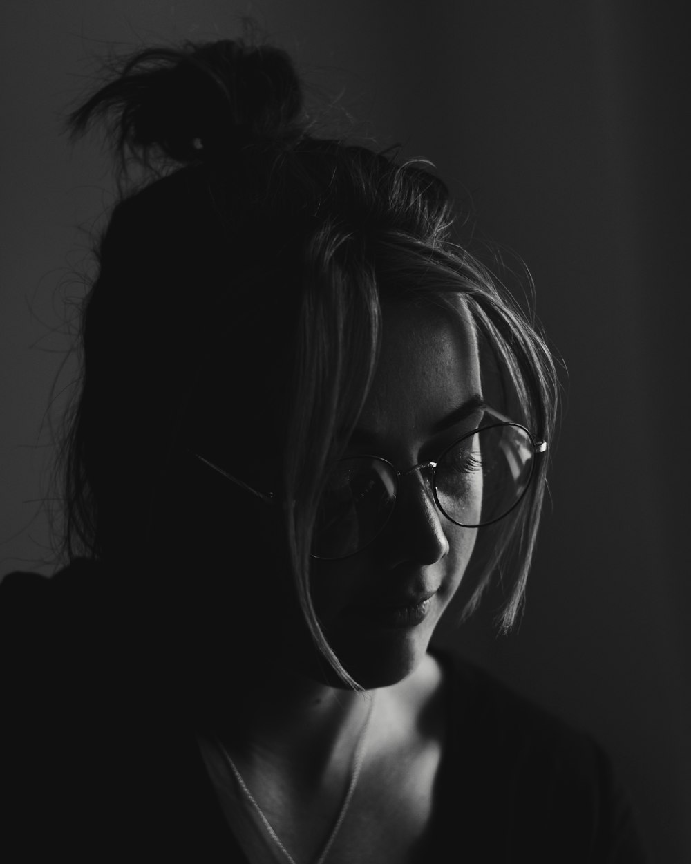 a black and white photo of a woman with glasses