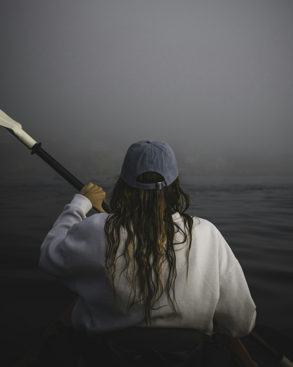 woman in white long sleeve shirt holding a stick