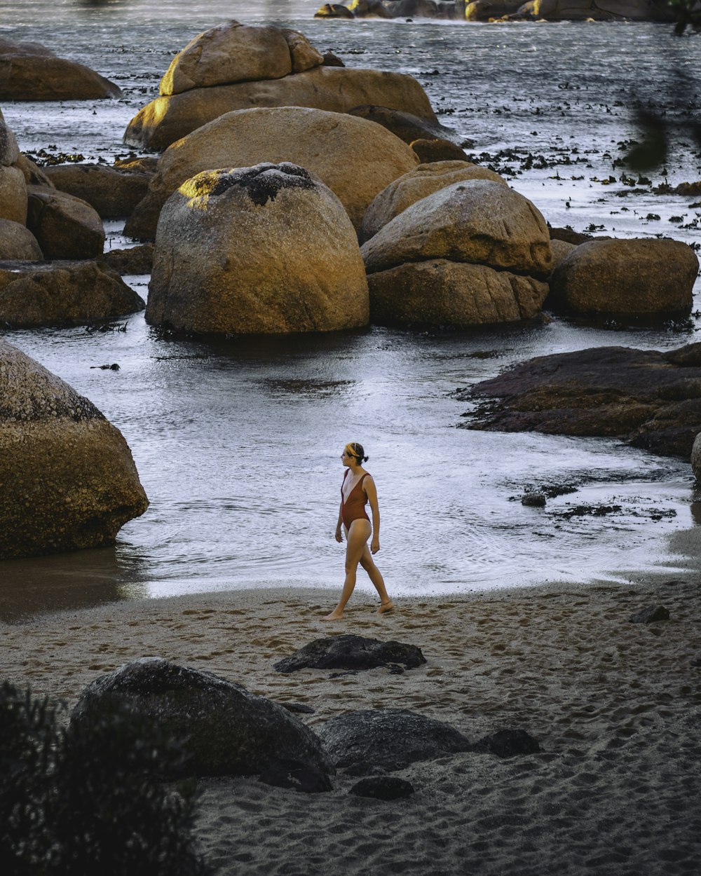 woman in black bikini walking on seashore during daytime