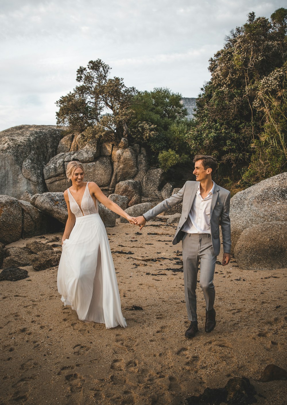 woman in white dress holding man in gray suit jacket