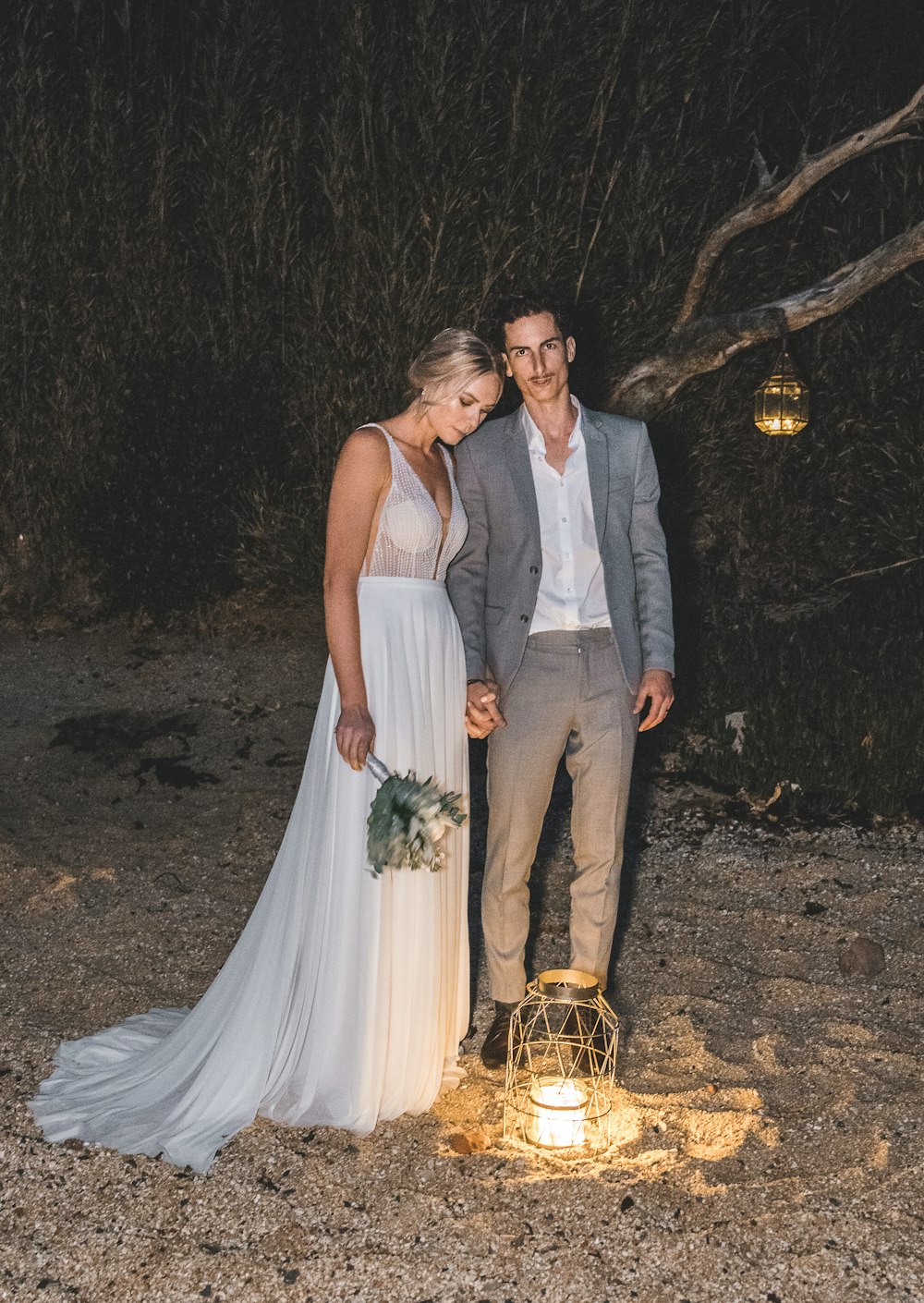 man in gray suit jacket beside woman in white sleeveless wedding dress