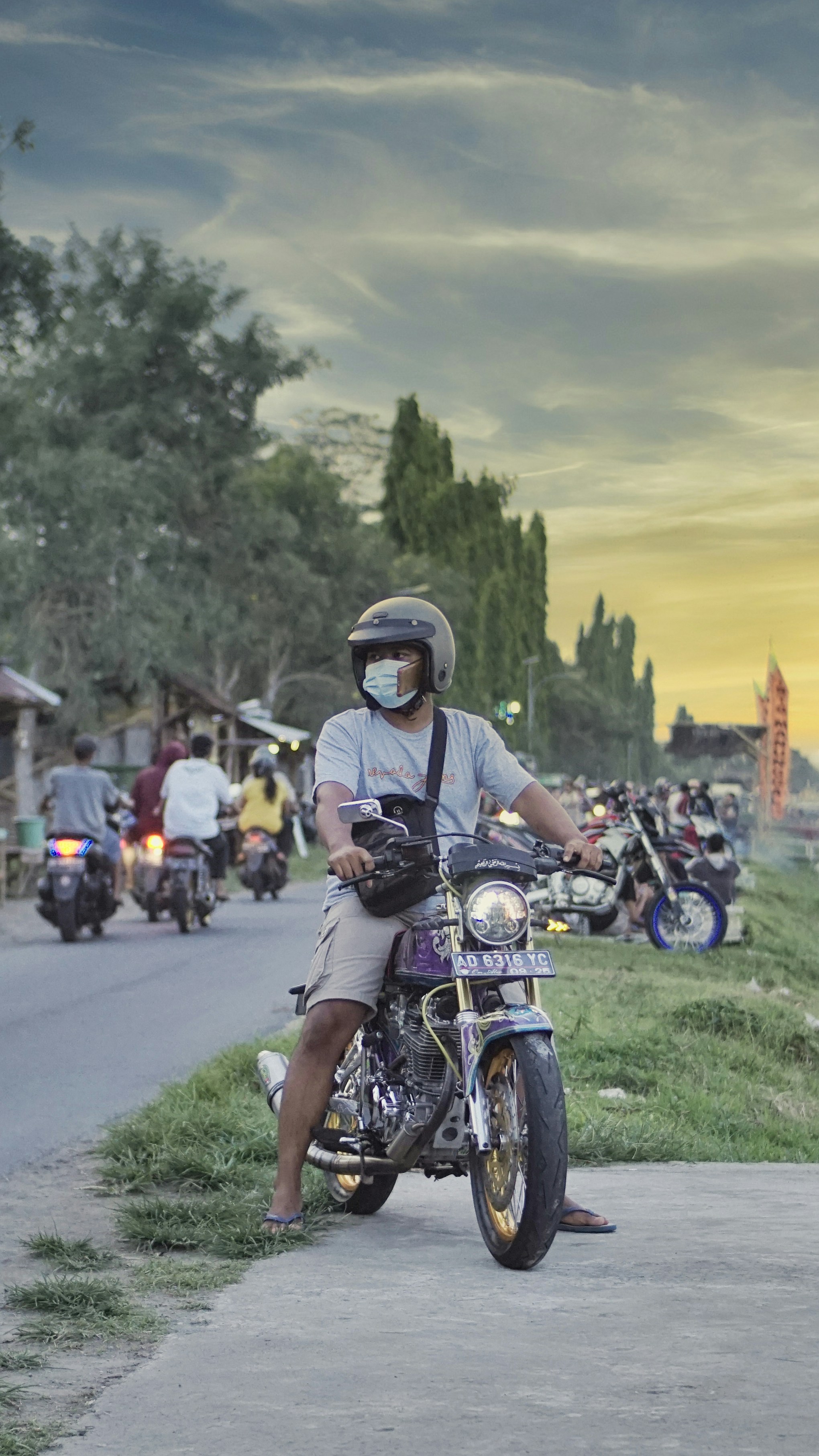 Pria berbaju hitam mengendarai sepeda motor di siang hari