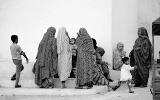 A group of volunteers warmly interacting with local families in a vibrant Indian village setting.
