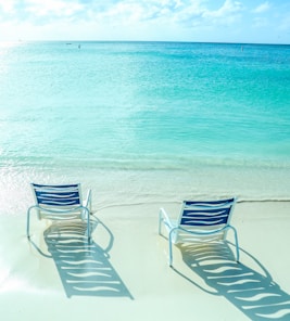 white and blue striped lounge chair on beach