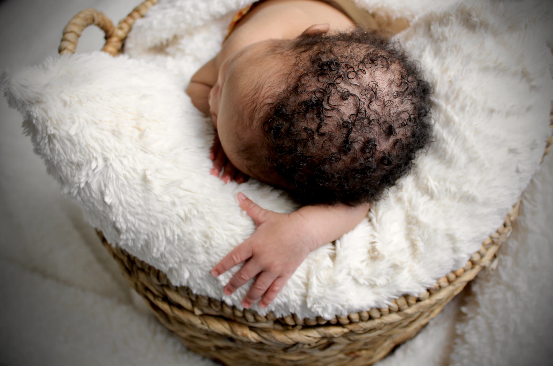 baby lying on white textile