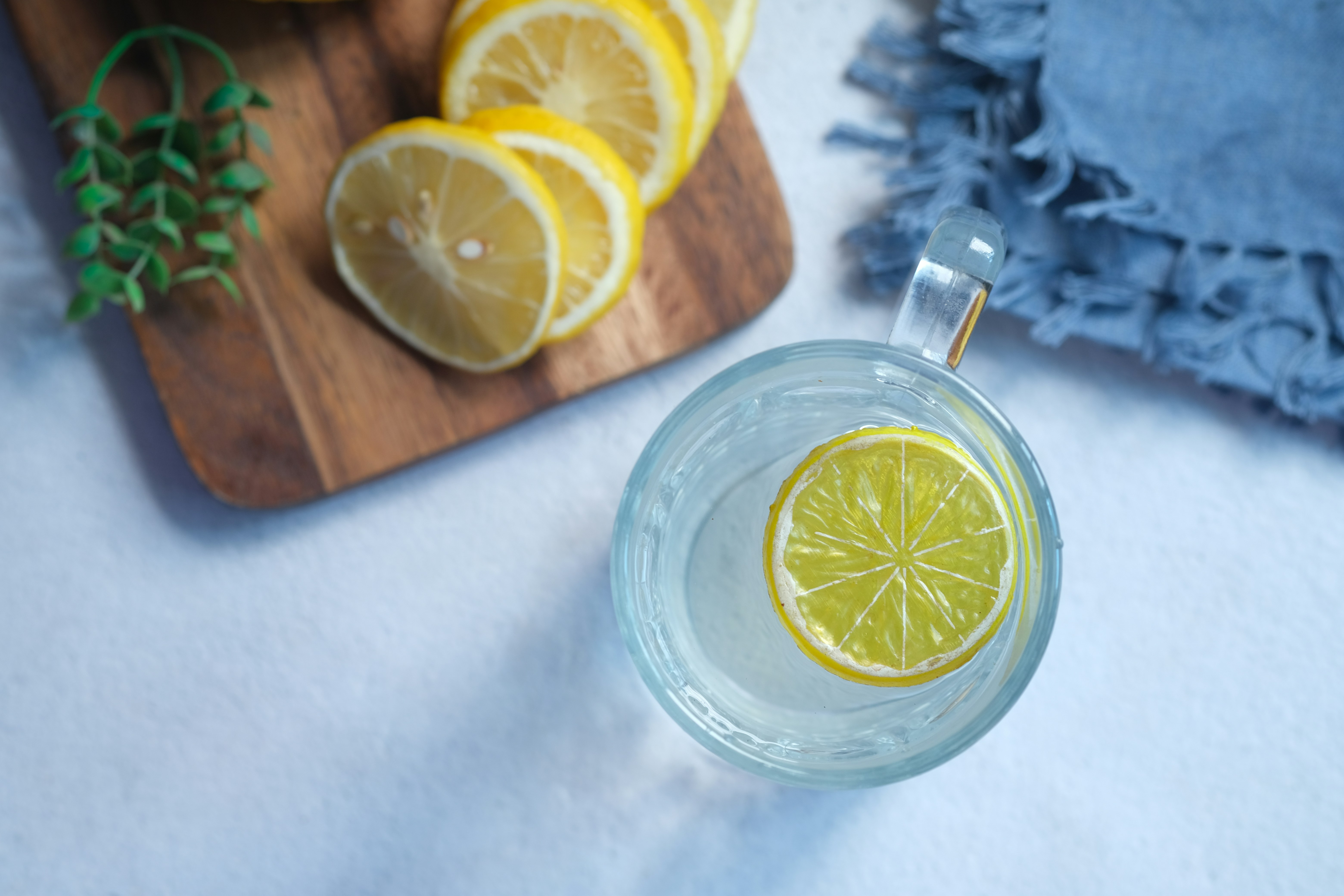 sliced lemon on clear glass saucer, Refreshing drink with lemon on table , top view 