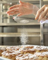 Artisan preparing fresh sweets in a clean, modern kitchen with natural light.