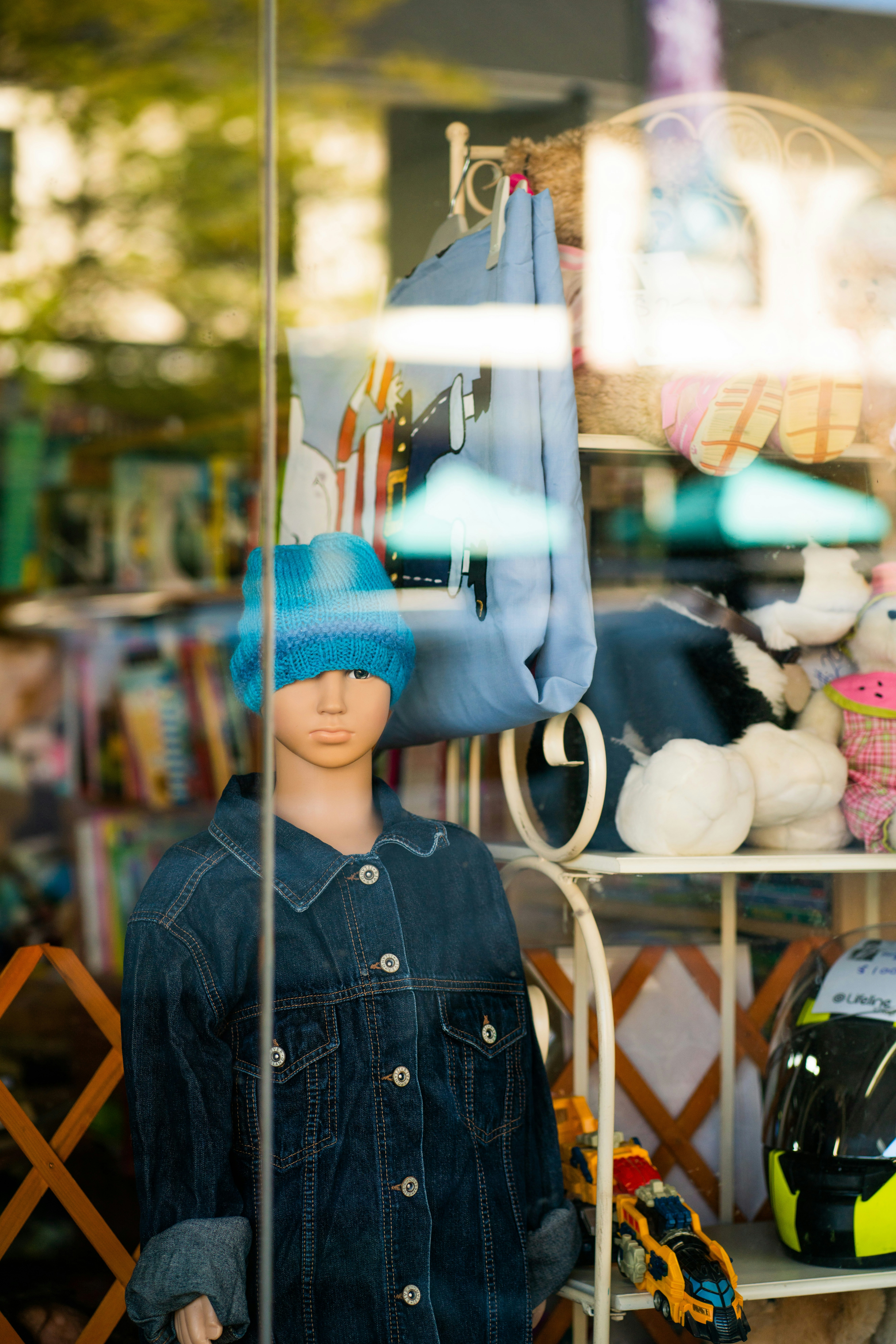 boy in black button up jacket standing near glass window