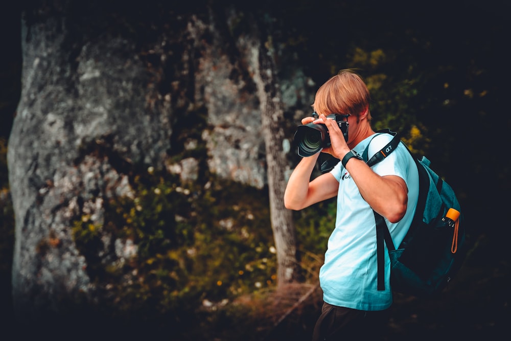 woman in white shirt taking photo using black dslr camera