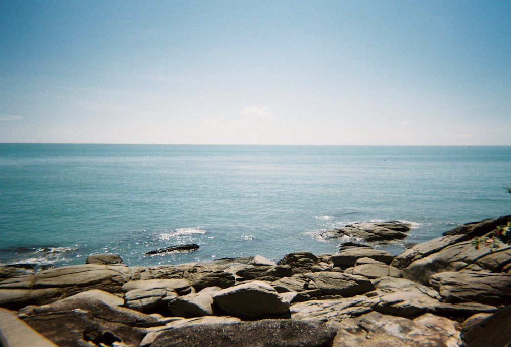 gray rocks near body of water during daytime