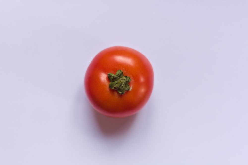 tomate rojo sobre mesa blanca