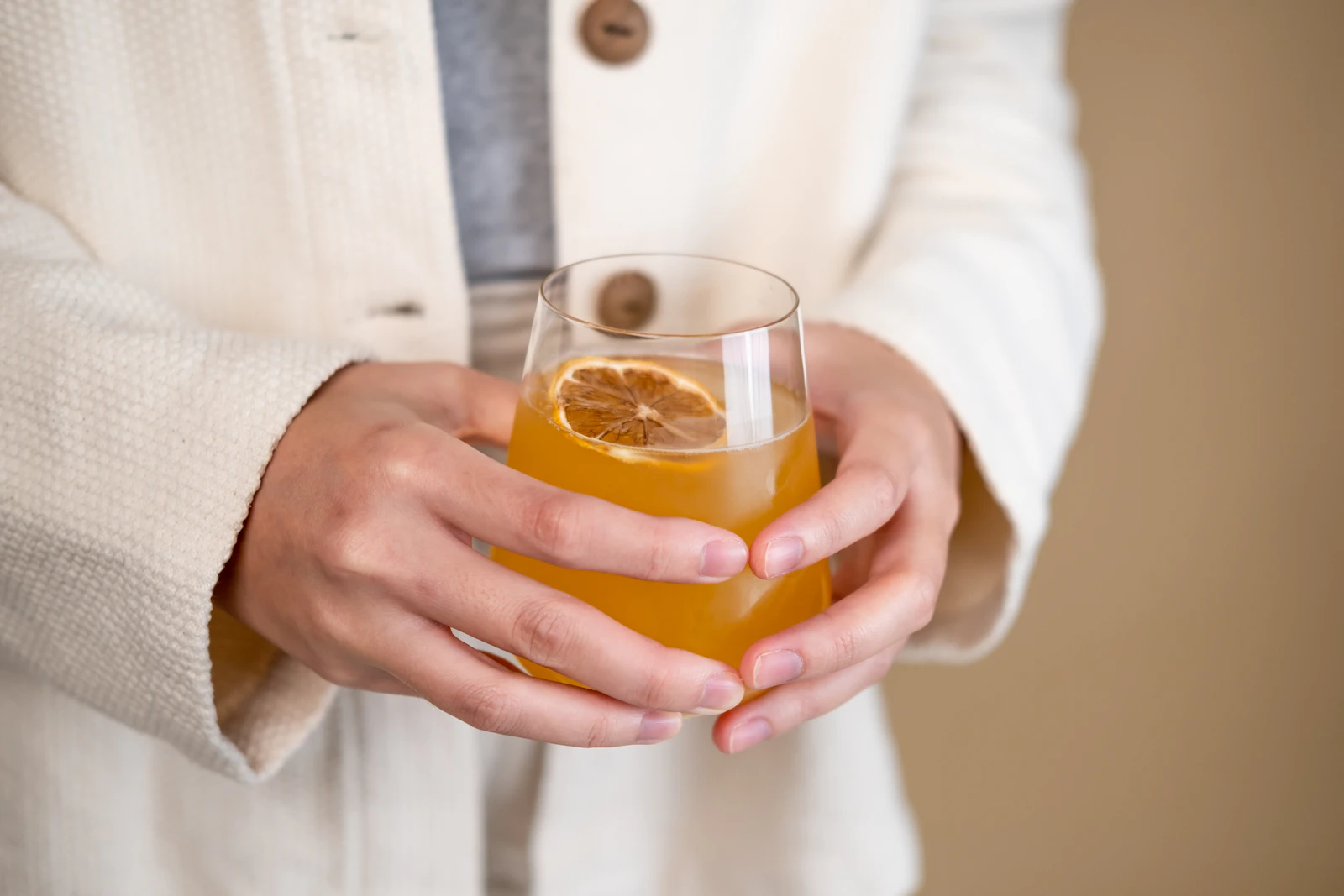 A refreshing amber drink held up in natural light.