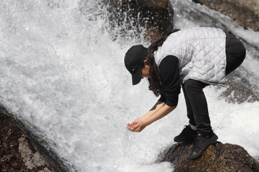 man in black and white stripe shirt and black pants standing on water