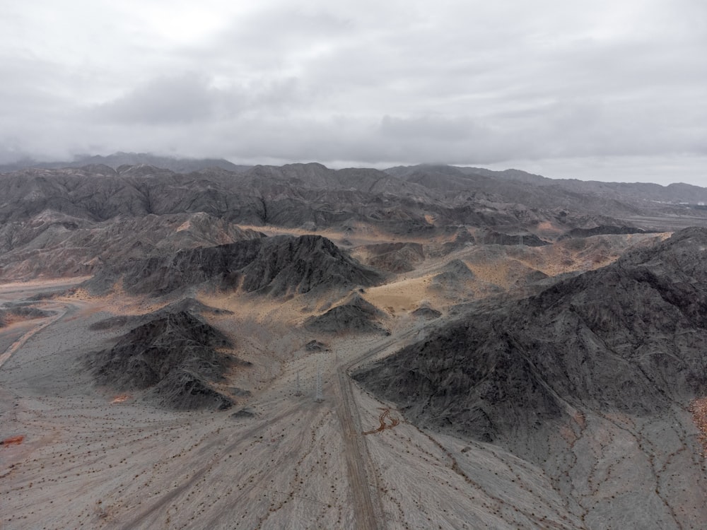 Montañas marrones y verdes bajo nubes blancas durante el día