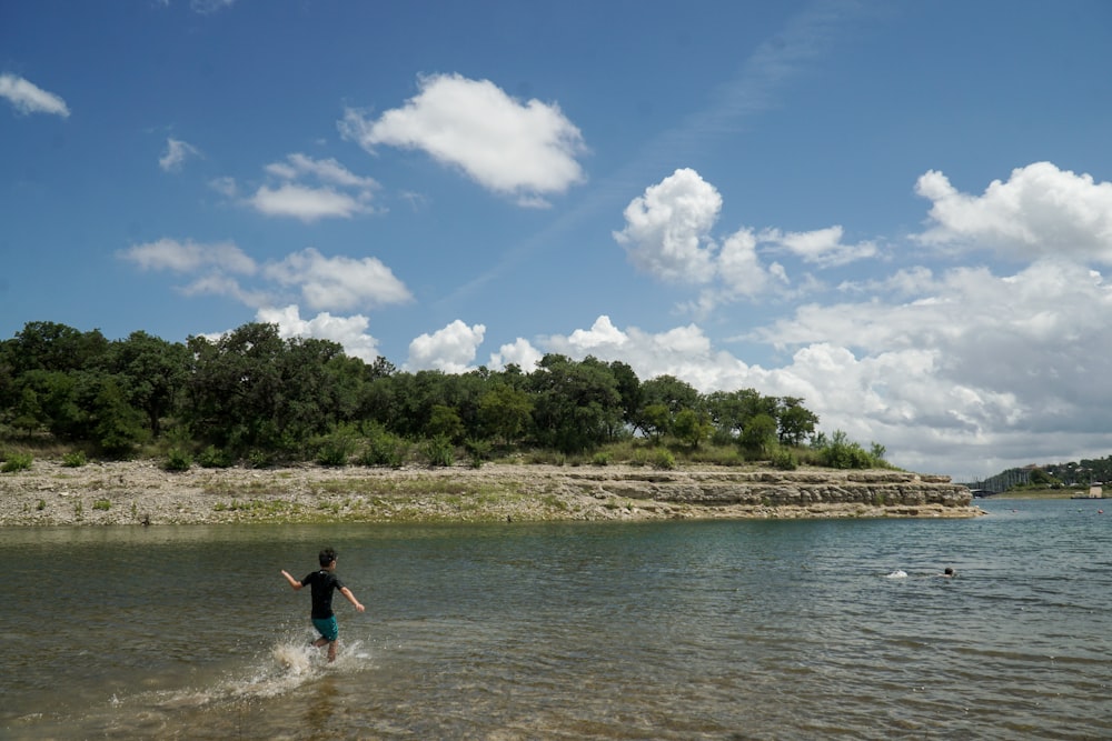 man in black shorts standing on water during daytime