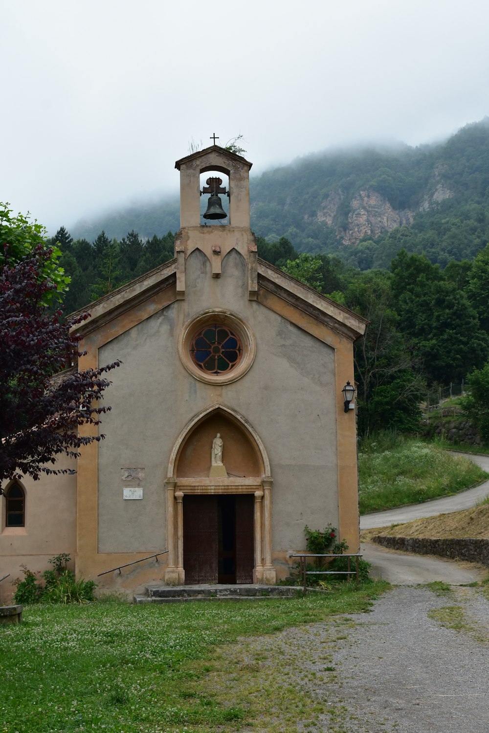 brown concrete church near green trees during daytime