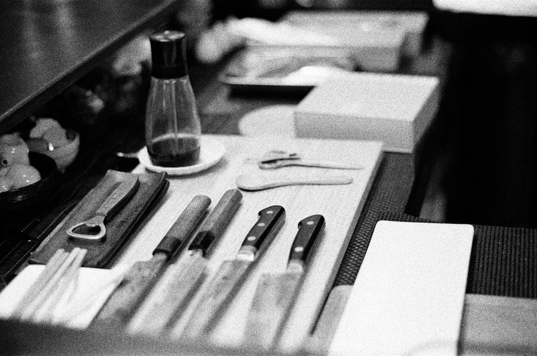 grayscale photo of pen and scissors on table