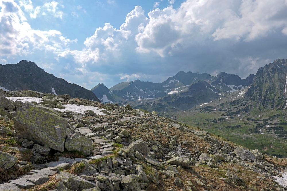 rocky mountains under white clouds and blue sky during daytime