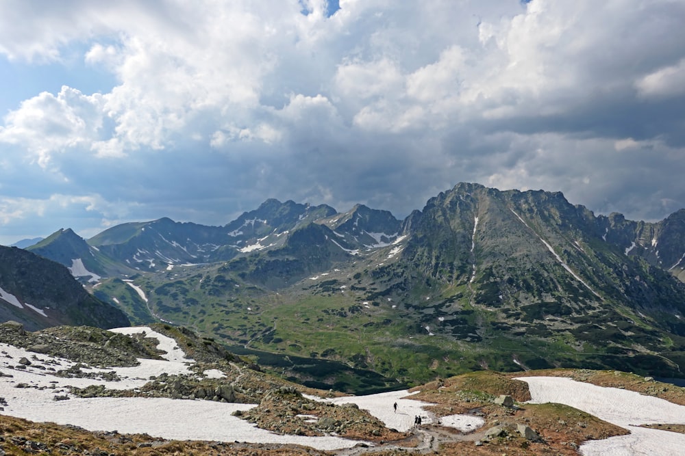 snow covered mountains under cloudy sky during daytime