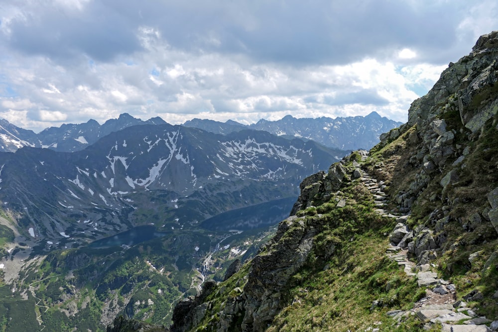 Grüne und schwarze Berge unter weißen Wolken und blauem Himmel tagsüber