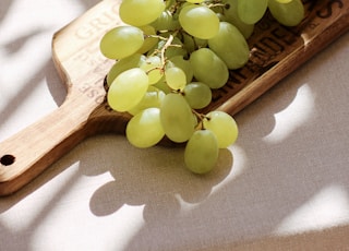 green grapes on brown wooden chopping board