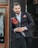 man in black suit holding red rose bouquet