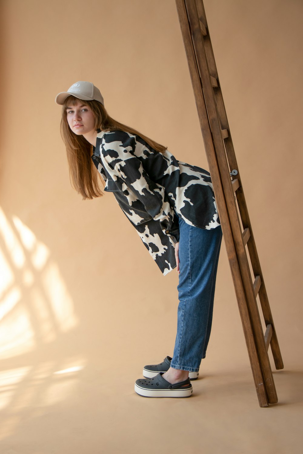 woman in black and white floral long sleeve shirt and blue denim jeans standing beside yellow