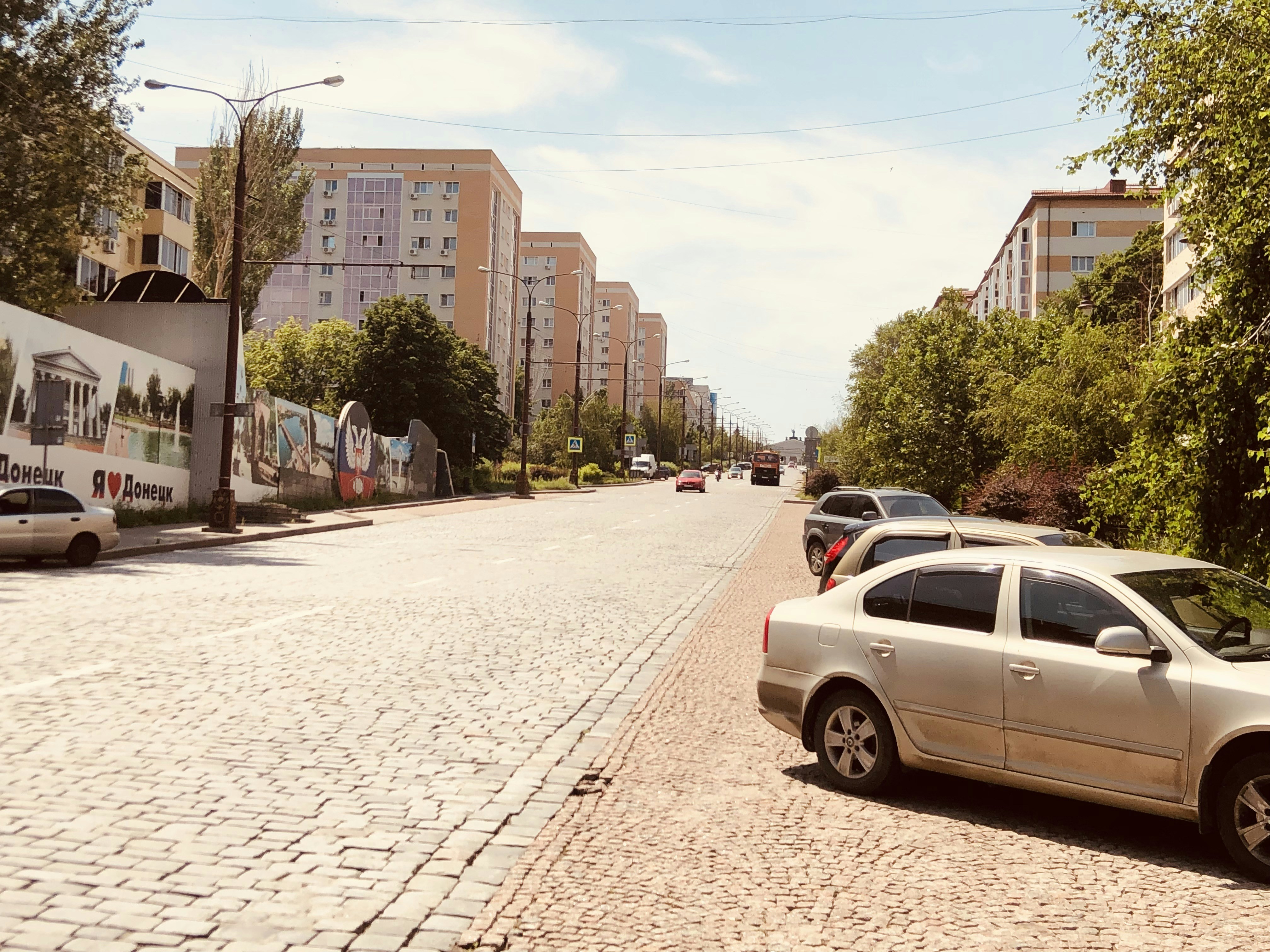 white sedan on road near buildings during daytime