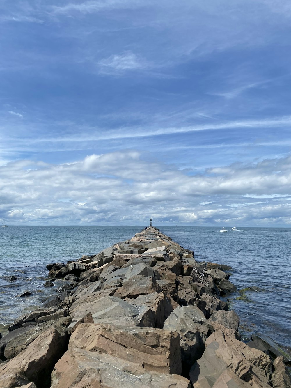 gray rocks on sea shore under blue sky during daytime