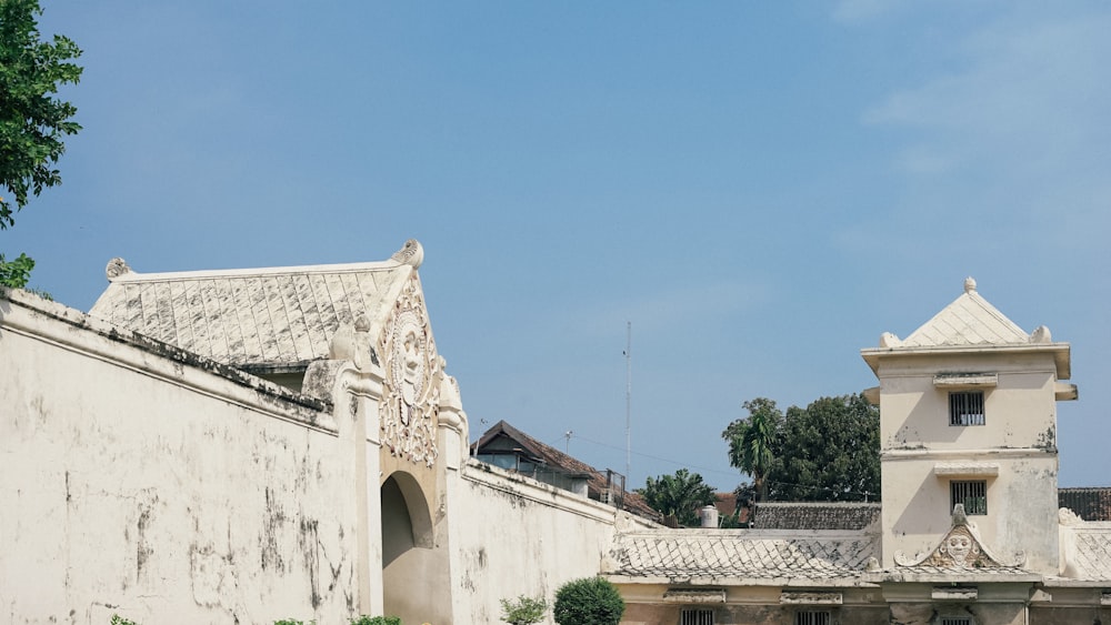 edificio in cemento bianco vicino agli alberi verdi durante il giorno