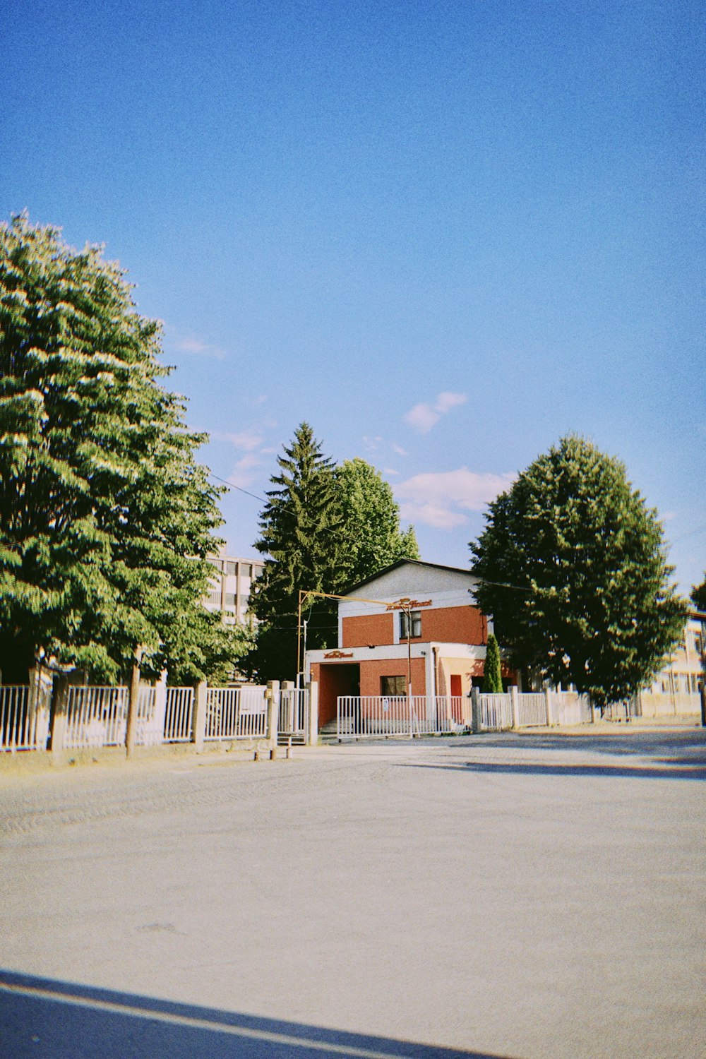 green trees near red and white house during daytime