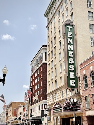 brown concrete building with green and white signage