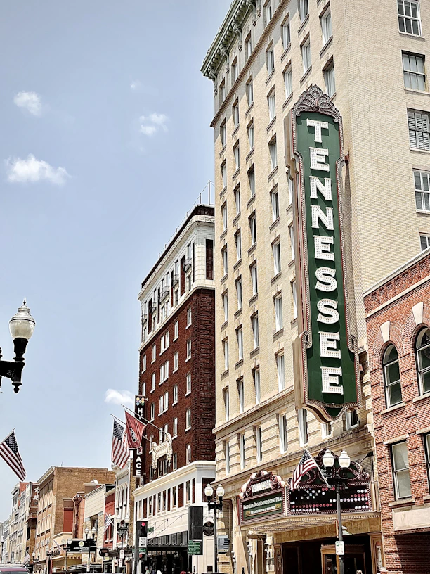 brown concrete building with green and white signage