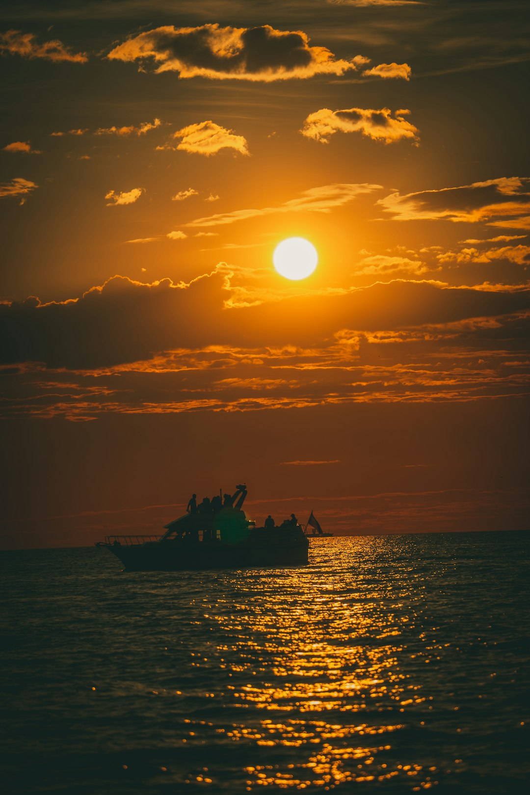 silhouette of people riding boat during sunset