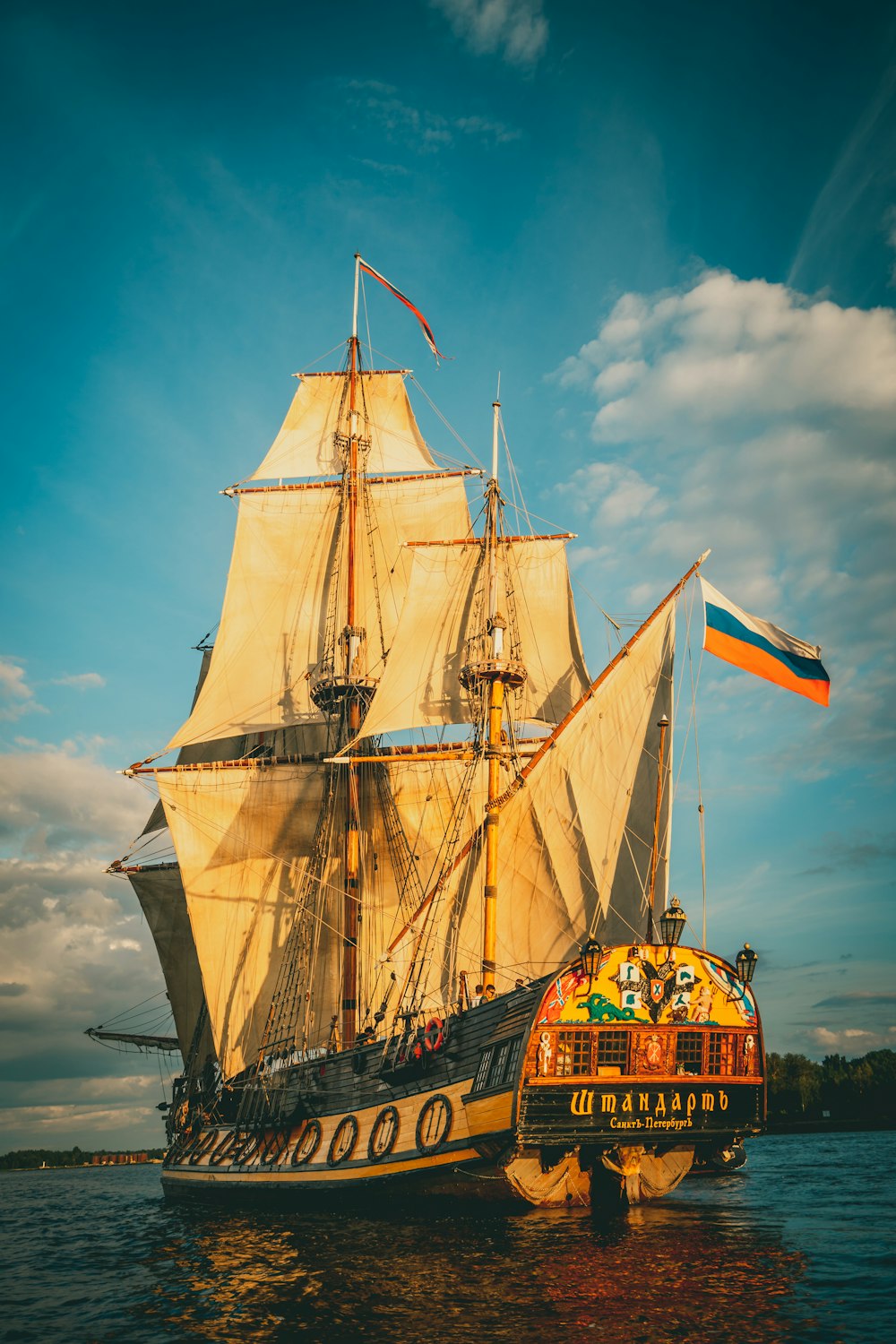 brown and black sail ship on sea under blue sky during daytime