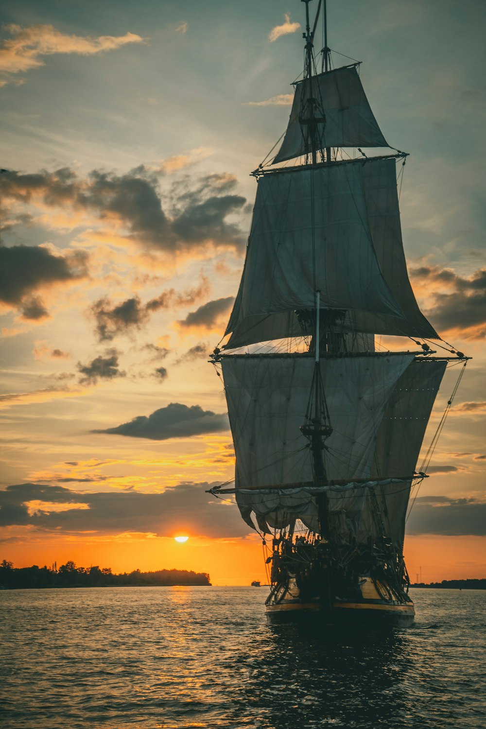 silhouette of ship on sea during sunset