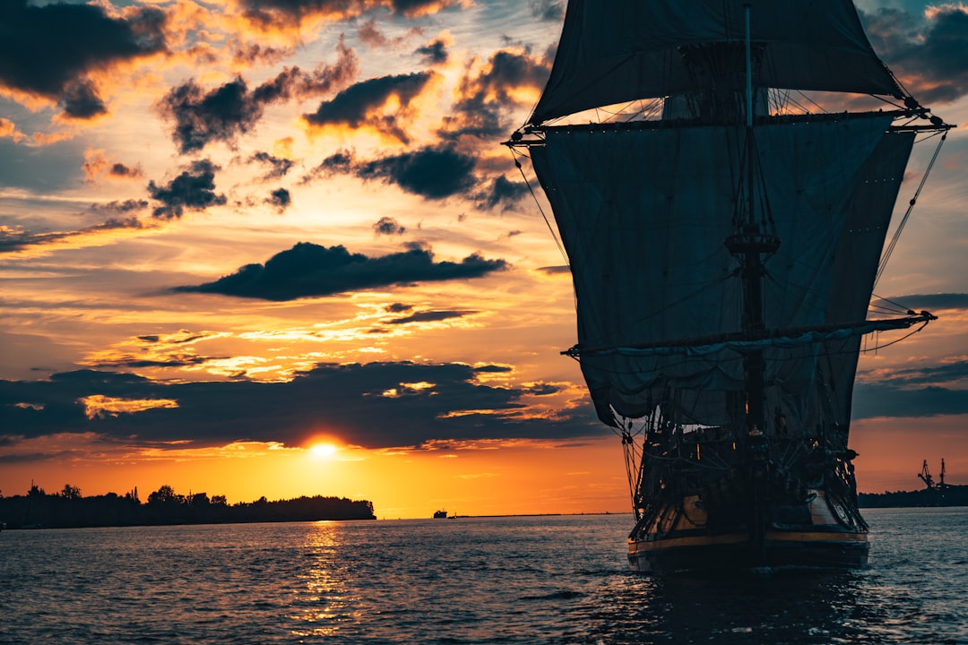 silhouette of ship on sea during sunset