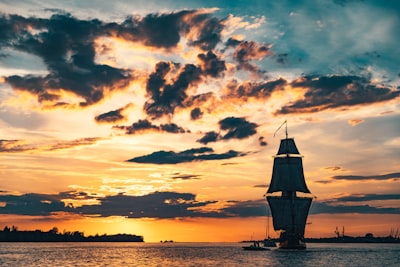 silhouette of boat on sea during sunset voyage google meet background