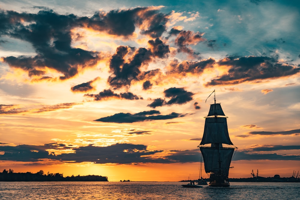 silhouette of boat on sea during sunset